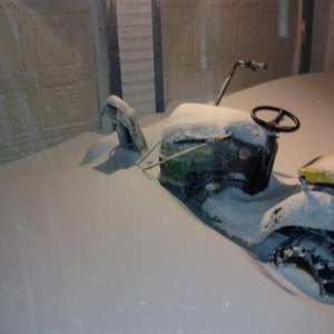 Lawn mower with a snowblower on the front. It was sitting outside for a couple hours and got buried. You can only see the chute in this picture becaus