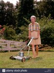 1960s-senior-woman-pushing-electric-lawn-mower-cutting-grass-kg3628-M66M6P.jpg